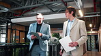 Office, businessmen and walk with tablet, discussion and financial forecasting with report and info. Economist, collaboration and people with tech, brainstorming and business strategy with paperwork