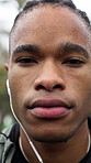 Face, fitness and sweat with black man outdoor in park for sports development or progress. Earphones, exercise and streaming with runner in nature for commitment or dedication to health and wellness