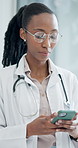 Phone, doctor and black woman in clinic for medical text, wellness email and digital results. Mobile, reading or healthcare worker in hospital for telehealth research, online report or typing message