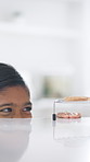 Peeking, child and steal in home with cookies, temptation and playful secret for dessert. Sneaky, girl and naughty with smile at house for baking craving, mischief and homemade treats for taste test
