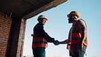 Engineer, people and handshake on construction site with collaboration, deal or discussion for project. Low angle, men talk or shaking hands in building with PPE, infrastructure teamwork or agreement