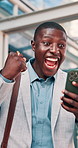 Fist pump, cellphone and black man in glass office with winning, capital gain or approval on investment. Excited, phone and financial manager with celebration for finance achievement in workplace.