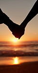 Holding hands, beach and couple with sunset, silhouette and honeymoon for vacation and travel. Sea, ocean and tropical adventure with people together for love, support and marriage or date on holiday