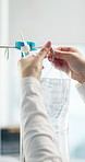 Hospital, hang and hands of nurse with iv drip, medicine and solution for patient recovery or healing. Healthcare, clinic and person with liquid for treatment, fluid and antibiotics for wellness