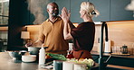High five, cooking and couple in kitchen at house for bonding, love and connection in marriage. Happy, celebration and mature man with woman for preparing food, dinner or supper together in home.
