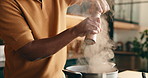 Salt, cooking and hands of man in kitchen at house for meal, dinner or supper with healthy diet. Steam, pot and male person with preparing dish for wellness, nutrition or recipe in apartment.