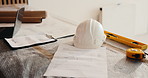Helmet, construction and documents on site for architecture planning, building or development. Empty, paperwork or PPE equipment with floor layout for civil engineering, project maintenance or design