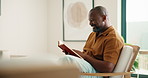 Relax, black man and reading book in house with funny story, smile and literature on weekend break. Novel, happy and mature person on armchair at living room with fantasy humor or laughing in home