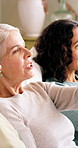 Bonding, relax and talking with women on sofa in living room of home together for reunion or visit. Break, conversation and pointing with mature friends in apartment for hangout to social gathering