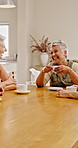 Women, laugh and friends in home with coffee, gathering and discussion with funny story. Smile, mature people and talking in lounge with beverage, tea time and comic conversation for weekend reunion