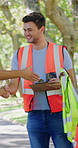 Volunteer, team and handshake in park with clipboard, PPE or writing for NGO service registration. People, shaking hands or talk outdoor with safety vest, checklist or application for charity project
