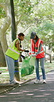 Volunteer, team and trash bag in park with garbage collection, charity project and waste management. Happy women, clean outdoor and plastic for rubbish, sustainability or eco friendly NGO initiative.