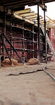 Scaffolding, construction or empty brick wall on site for development process, safety or equipment. Masonry, residential structure or upgrade project for house renovation, progress and roofing beams
