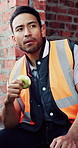 Worker, man and eating at construction site with break, fruit and thinking for building renovation. Person, apple snack and builder rest outdoor with industrial job, vision or contemplation for work.
