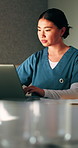 Serious, nurse and woman with laptop in clinic, administration and typing medical records on website. Healthcare, online and person with tech for test results, information or paperwork in hospital