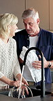 Washing, dishes and senior couple in kitchen, hygiene and discussion with partner on weekend in home. Happy, mature people and chat with spouse, housework and cleaning together with smile in house