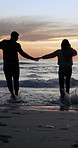 Running, beach and couple holding hands for holiday, vacation and bonding on summer weekend. Sunset, splash and back of man and woman for playful relationship, love and romantic moment by ocean