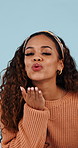 Face, woman or blow kiss in studio for love, romantic gesture or flirting expression for valentines day. Portrait, confident and happy person with affection for anniversary, wave and blue background
