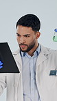 Science, tablet and man in studio with test tube, chemicals and research for medical analysis. Healthcare, chemistry and scientist with sample, experiment and tech for vaccine on white background