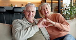 Senior, face and couple with heart hands in home for love, romance or retirement together. Portrait, elderly man and woman relaxing with smile, emoji or passion for romantic gesture or date in house