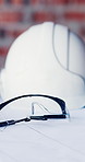 Architecture, empty and helmet on desk for construction, planning and blueprint for building. Engineering, background and ppe with paperwork for safety compliance, renovation and infrastructure