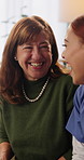 Laughing, caregiver and senior woman in nursing home, healthcare and bonding with patient in lounge. Happy, nurse and funny discussion with mature person on couch, retirement and chat in living room