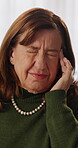 Headache, tired and stress with old woman in home for frustrated, fatigue and brain fog. Migraine pain, worry and temple massage with person in living room of apartment for  crisis and overwhelmed