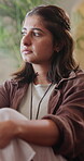 Sad, thinking and worry with woman on sofa in home for regret, grief memory and reflection. Mental health, trauma and disappointment with person with depression in living room of apartment with fear