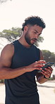 Man, phone and break in nature with fitness app, browsing online and thinking for cardio exercise. Active person, breathing and typing outdoor with tech, social media update and workout for wellness.