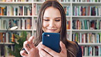 Student, woman and browse in library with phone, education or social media notification on study break. Person, smile or scroll on college campus with tech, text message and reading university email.