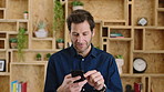 Man, phone and chat with texting at office, communication or check notification at startup. Mature person, happy and typing on mobile app, contact or scroll on social media for job at creative agency