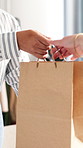 Hands, customer or purchase with shopping bag in clothing boutique for fashion or checkout. People, cashier or packing with paper parcel or package for accessory, service or commerce in store or shop