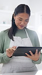 Cooking, tablet and Asian woman in kitchen for recipe, online instruction and tutorial for meal prep. Home, tech and person with research, lunch ideas and inspiration on culinary website or food blog