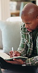 Sofa, writing or black man with book in home for remote work, schedule or checking tasks. Male person, freelancer or planning with diary, laptop or notebook for information, agenda or report in house
