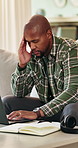 Black man, laptop and headache with remote work from home on sofa, notes and stress in living room. African person, virtual assistant and migraine in lounge with pc, feedback and insight at house