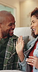 Couple, high five and happy on sofa with smile, bonding and connection with celebration in living room. African people, success and chat on couch with laughing, relationship or achievement in lounge