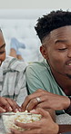 Laptop, happy and black couple on bed with popcorn, streaming and watching movie together. Marriage, love and man with woman with snack, conversation and bonding with series on weekend in home
