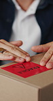 Person, hands and box with fragile label for logistics, small business distribution or delivery. Top view, distributor or supplier with caution sticker on courier package or parcel for freight safety