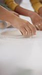 Hands, family and baking at house with dough, learning and culinary skills for homemade cookies. People, rolling pin and teaching kid in home for lesson, pastry recipe and guidance for handmade bread