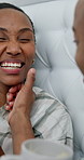 Touch, laugh and black couple in bedroom with coffee, conversation and bonding on weekend. Marriage, happy and man with woman with drink for talking, discussion and wipe face for connection in home