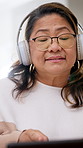 Mature woman, singing and dancing with headphones in house, fun or listen to song with subscription. Happy, Asian person and rhythm with laptop, movement and streaming music on weekend in lounge