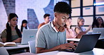 Man, laptop and typing in classroom at college for notes, review and development with education. Person, computer and students with attention for learning, scholarship and assessment at university