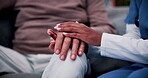 Console, empathy and nurse holding hands with old person in retirement home for healthcare. Comforting, security or support with caregiver and senior patient on sofa in apartment for medical care