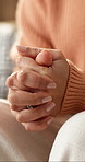 Anxiety, nervous and hands of woman on sofa for overthinking, unsure and worry for mental health. Home, therapy and person with stress for fidget, overwhelmed and trauma or fear habit in living room