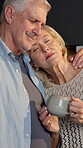 Peace, couple and coffee with hug in home for marriage security, healthy relationship and bonding. Beverage, mature people and safety with embrace for affection, connection and commitment for loyalty