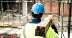 Man, architect or walking with concrete on construction site for building material or foundation. Back view, male person or contractor with equipment or gear for structure or architecture development