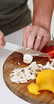 Cooking, hands and person with healthy food for nutrition, meal prep and cutting ingredients for lunch. Diet, vegetables and home chef in kitchen with knife, recipe and culinary skills with mushrooms
