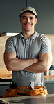 Face, plumber and happy man in kitchen with arms crossed, repair skills and pride for maintenance job. Confident, person and handyman in home with tool belt, smile and about us for plumbing company.