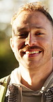 Face, man and travel with hike in forest for fresh air, explore and adventure on holiday or smile. Outdoor, happy hiker and portrait for sightseeing on vacation, backpacking or wellness in nature