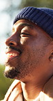 Man, hiking and thinking with smile in nature, breathing and mindfulness on peaceful holiday or trip. Hiker, laughing and black person with memory, fresh air and reflection on vacation and adventure